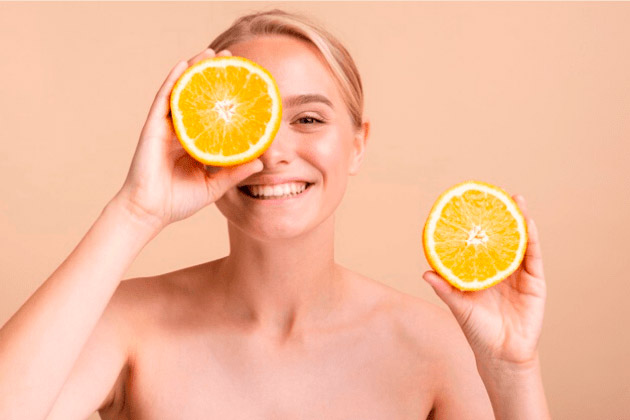 Modelo: Mujer sosteniendo una naranja